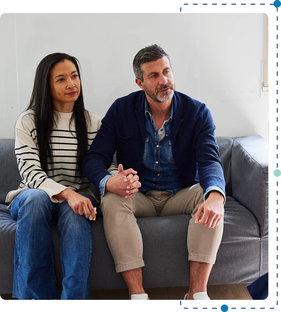 A man and woman sitting on top of a couch.